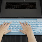 Teclado retrô azul sendo usado com notebook